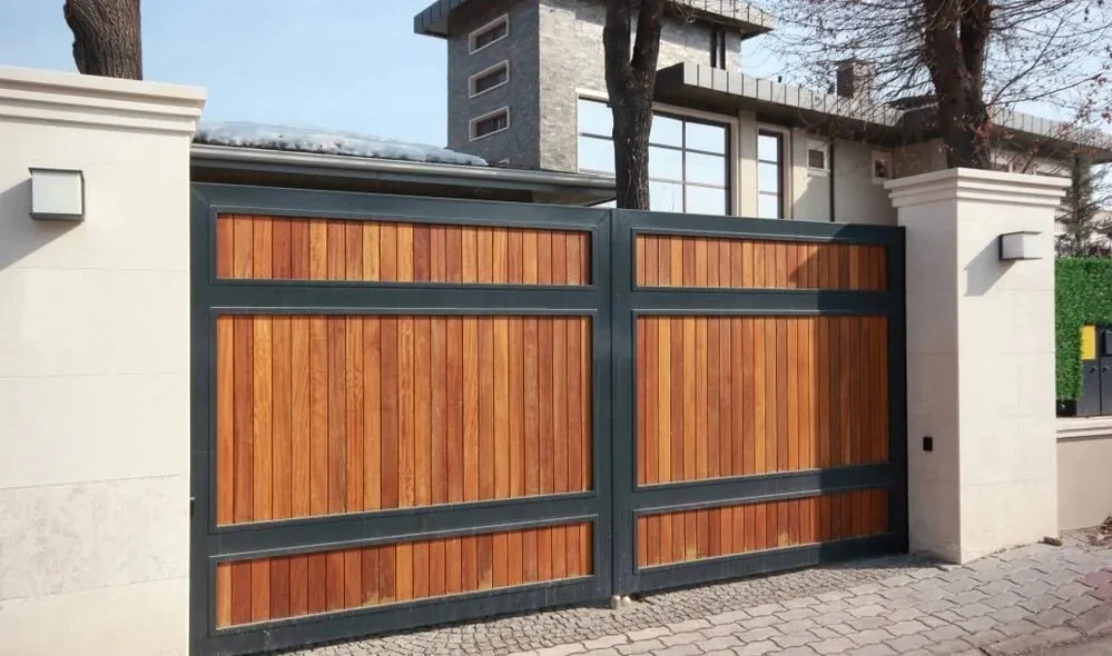 Arched driveway gate between brick pillars